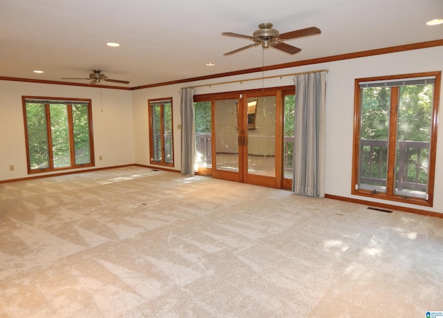 carpeted empty room featuring ceiling fan, a healthy amount of sunlight, and baseboards
