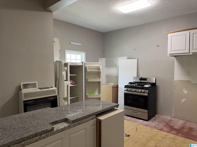 2030 Leighton Ave, Anniston, AL 36207 - kitchen featuring heating unit, fridge, white cabinets, stone countertops, and stainless steel gas range