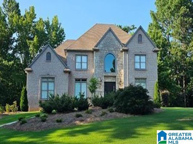 view of front of property with a front lawn and stone siding