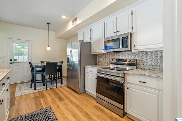 kitchen featuring visible vents, light wood-style floors, white cabinets, tasteful backsplash, and stainless steel appliances