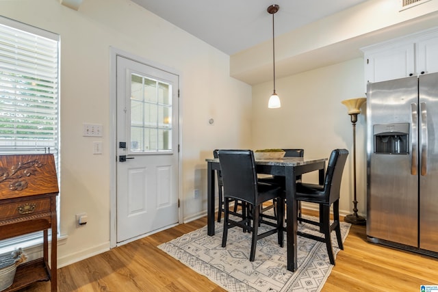 dining space with baseboards and light wood finished floors