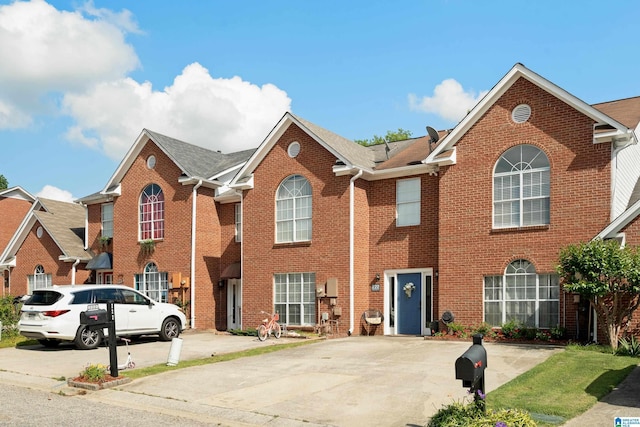 view of front facade featuring brick siding and roof with shingles
