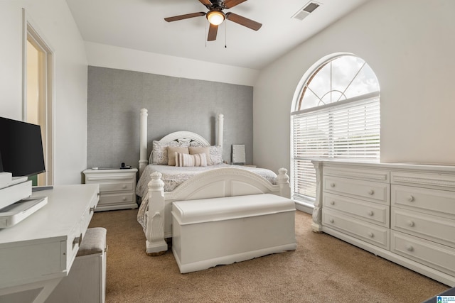 bedroom featuring visible vents, a ceiling fan, lofted ceiling, and light colored carpet