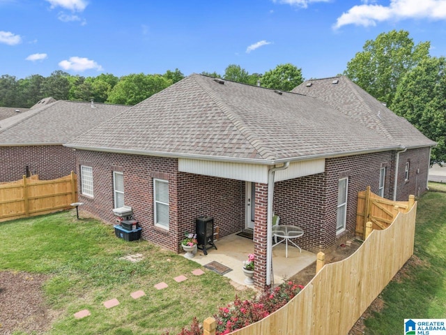 209 Vineyard Ln, Birmingham, AL 35242 - back of property with a shingled roof, brick siding, a fenced backyard, a patio area, and a lawn
