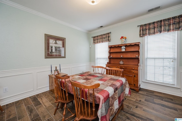 dining space with visible vents, dark wood-style floors, ornamental molding, and a wainscoted wall