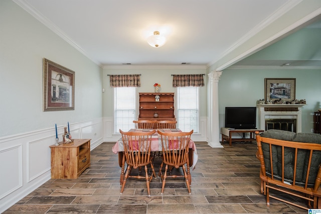 dining space with a fireplace, a decorative wall, decorative columns, wood tiled floor, and ornamental molding