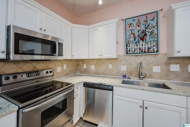 kitchen featuring stainless steel appliances, white cabinetry, and a sink