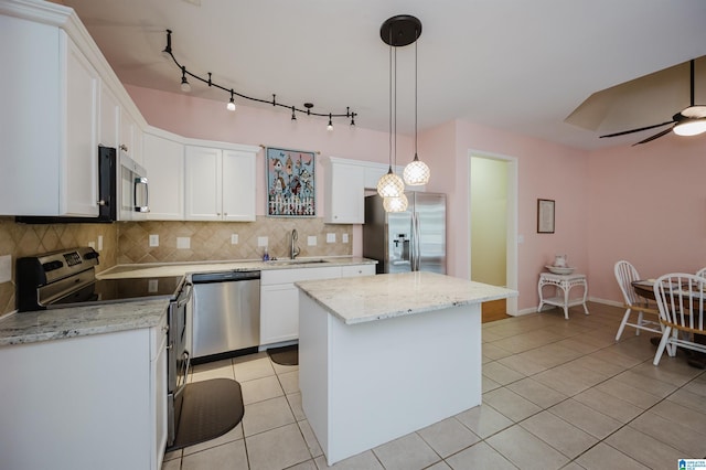 kitchen featuring light tile patterned flooring, a kitchen island, tasteful backsplash, and stainless steel appliances