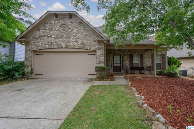 view of front of home with a porch, driveway, central AC unit, brick siding, and an attached garage