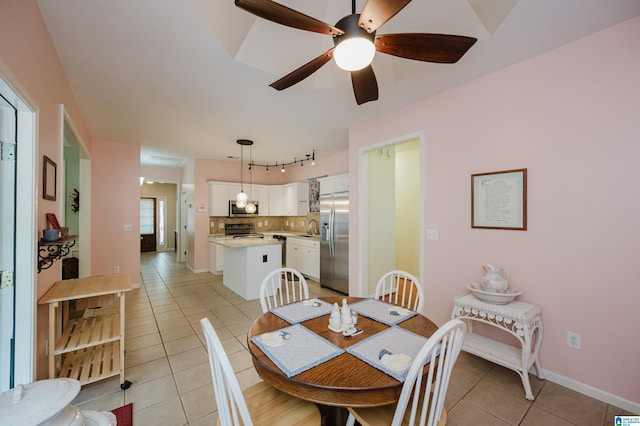 dining area with baseboards, a ceiling fan, and light tile patterned flooring