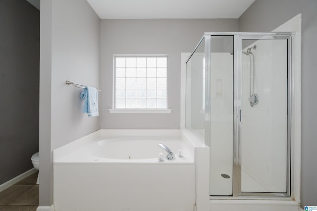 bathroom featuring toilet, tile patterned floors, a bath, and a stall shower