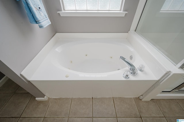 full bath featuring a whirlpool tub and tile patterned flooring