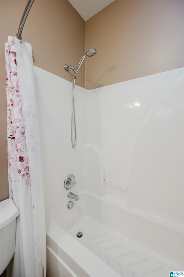 bathroom featuring shower / tub combo with curtain and toilet