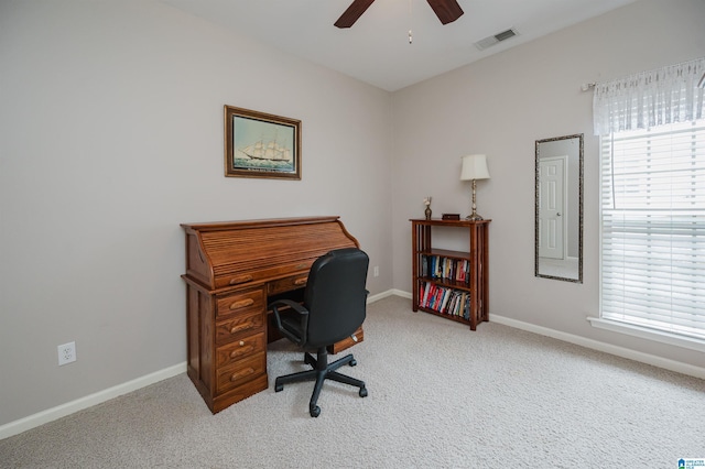 office featuring a healthy amount of sunlight, a ceiling fan, light colored carpet, and visible vents