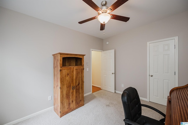 carpeted office space with baseboards and ceiling fan