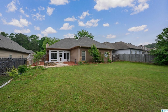 back of property with a yard, a fire pit, a fenced backyard, and a patio area