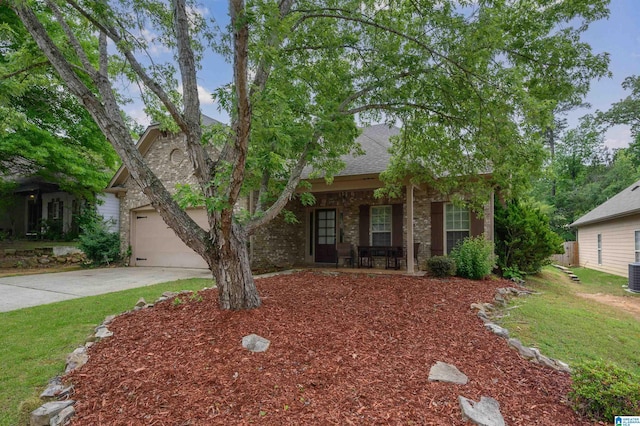 obstructed view of property with a garage, covered porch, stone siding, central air condition unit, and driveway