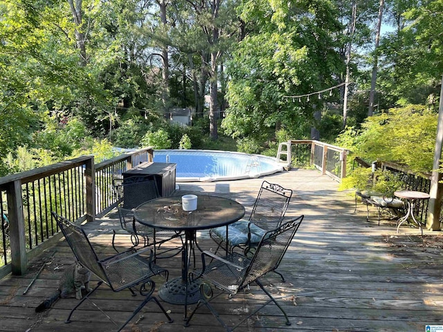 wooden terrace featuring outdoor dining area and an outdoor pool