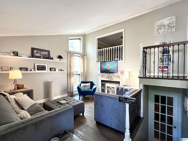 living area with crown molding, baseboards, wood finished floors, and a fireplace