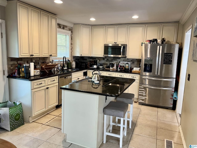 kitchen with a sink, decorative backsplash, stainless steel appliances, and visible vents