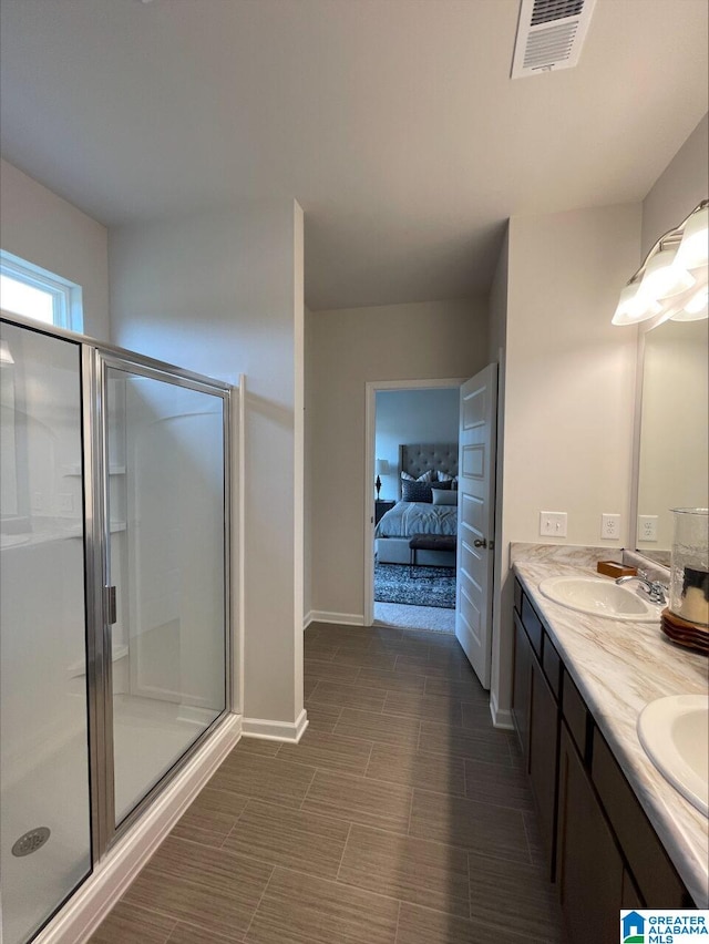 ensuite bathroom featuring a sink, a shower stall, double vanity, and visible vents