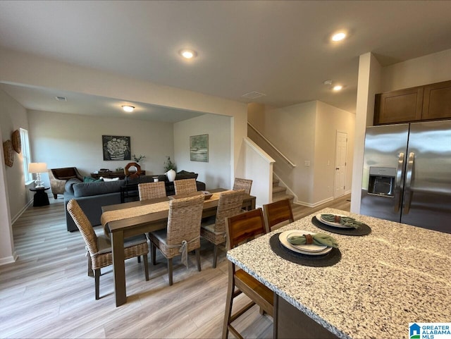 dining area featuring recessed lighting, baseboards, stairs, and light wood-style flooring
