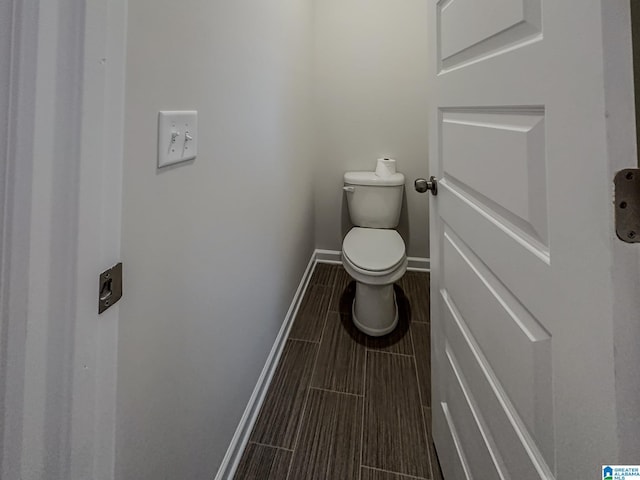 bathroom with baseboards and toilet