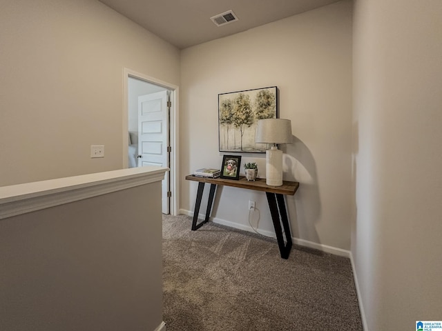 hall featuring baseboards, carpet, and visible vents