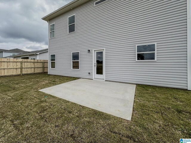 back of house with fence, a yard, and a patio area