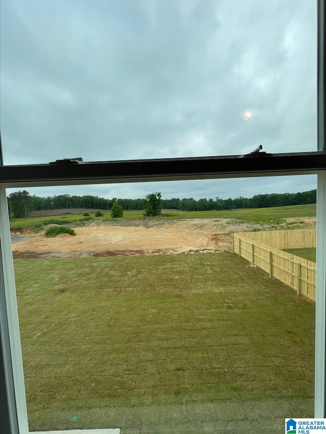view of yard featuring a rural view and fence