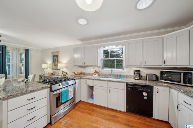 2105 NE 5th St NE, Center Point, AL 35215 - kitchen featuring crown molding, a peninsula, light wood-type flooring, a sink, and stainless steel appliances