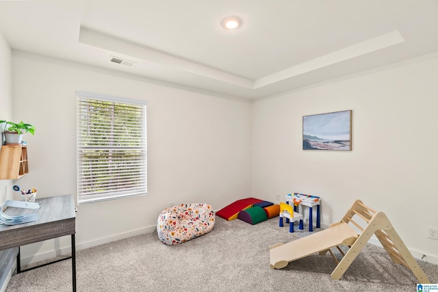playroom featuring baseboards, carpet, a raised ceiling, and visible vents