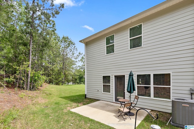 rear view of property with a patio, a lawn, and central AC