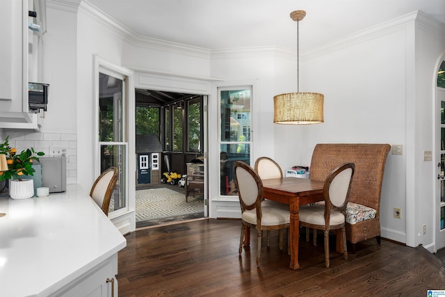 dining space with ornamental molding and dark wood-style flooring