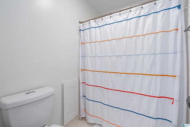 bathroom featuring a shower with curtain and toilet