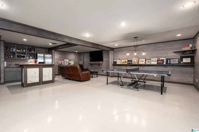 playroom featuring recessed lighting, wood walls, finished concrete flooring, and indoor bar