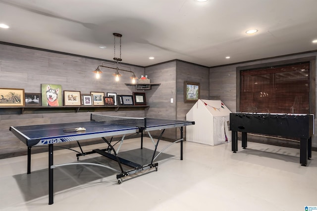 recreation room featuring recessed lighting, wood walls, and finished concrete flooring