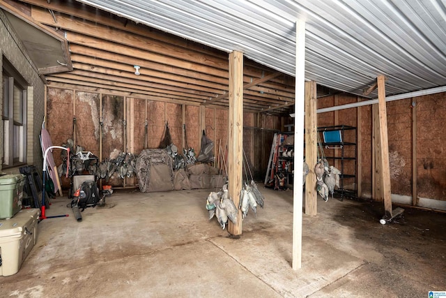 misc room with a garage and unfinished concrete flooring