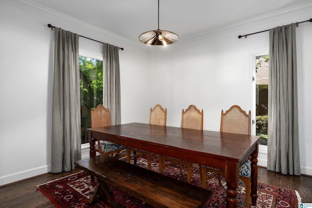 dining room with crown molding, baseboards, and wood finished floors