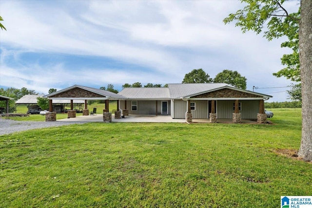 239 Gilliland Rd, Oneonta, AL 35121 - view of front facade with metal roof, gravel driveway, a front lawn, and stone siding