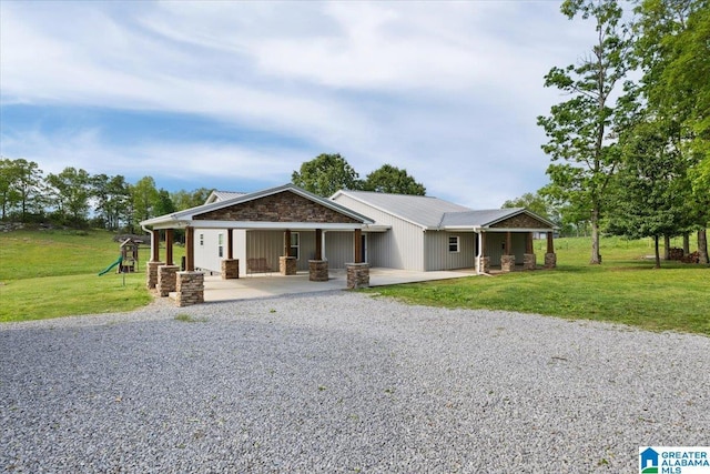 239 Gilliland Rd, Oneonta, AL 35121 - view of front facade featuring stone siding, a front lawn, a playground, and gravel driveway