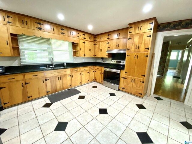 kitchen featuring stainless steel electric range oven, open shelves, a healthy amount of sunlight, and a sink