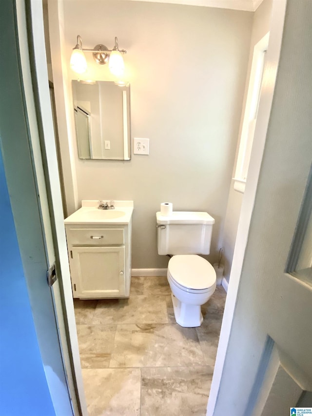 bathroom featuring vanity, baseboards, and toilet