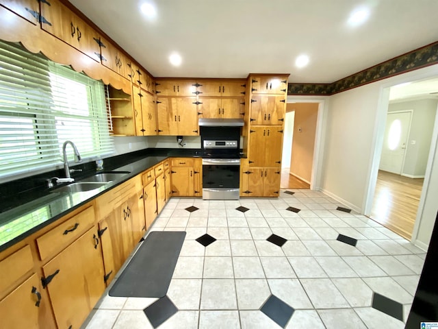 kitchen with stainless steel range with electric cooktop, dark countertops, open shelves, a sink, and baseboards