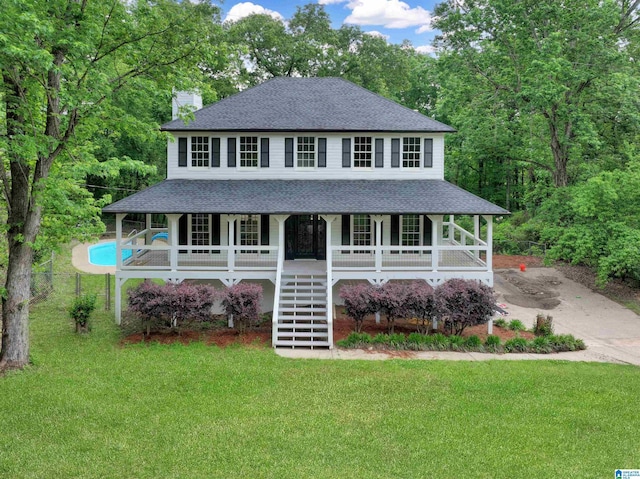 farmhouse inspired home with a porch, a front lawn, roof with shingles, and stairway