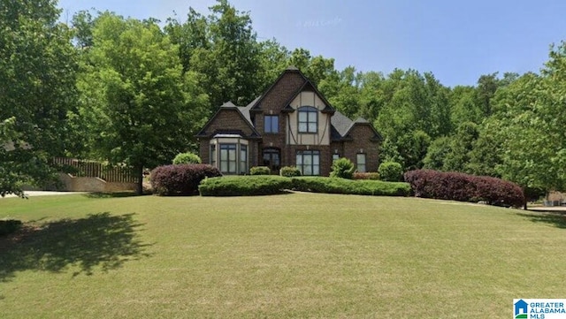 1103 Greystone Cove Dr, Hoover, AL 35242 - tudor-style house featuring a front lawn and fence