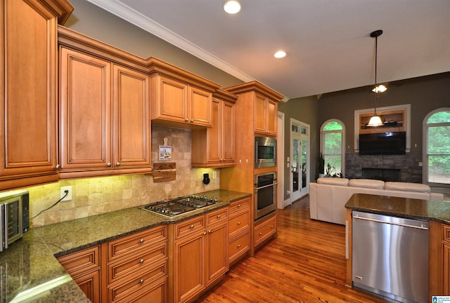 1103 Greystone Cove Dr, Hoover, AL 35242 - kitchen featuring decorative backsplash, wood finished floors, brown cabinets, appliances with stainless steel finishes, and decorative light fixtures