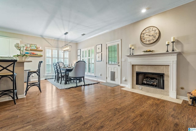 dining room with baseboards, a fireplace, wood finished floors, and a notable chandelier