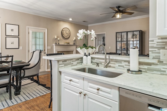 kitchen featuring stainless steel dishwasher, backsplash, ceiling fan, and a sink
