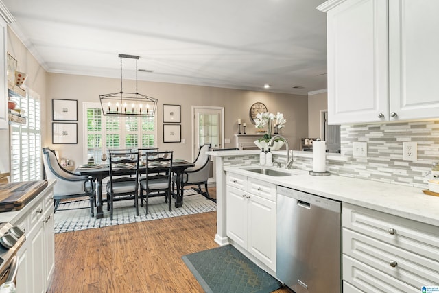 kitchen featuring a sink, stainless steel appliances, white cabinetry, wood finished floors, and tasteful backsplash